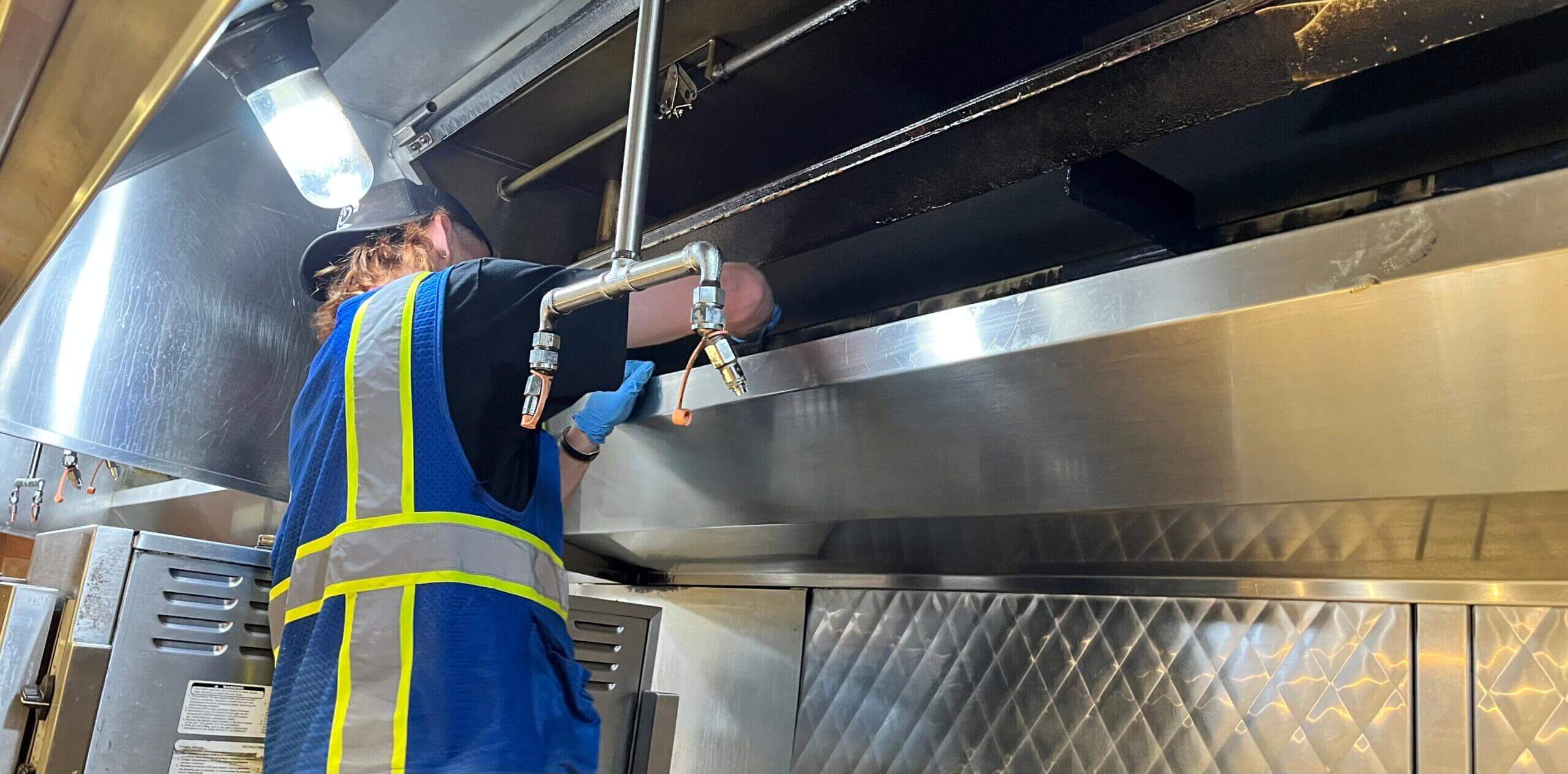 PowerWash Pro technician providing NFPA 96 compliant kitchen hood and duct exhaust cleaning services.