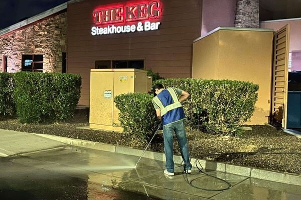 Pressure washing sidewalk at The Keg Steakhouse.