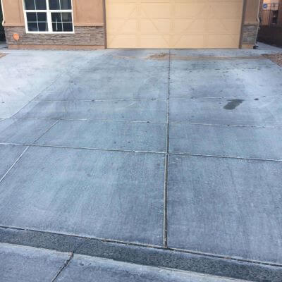 Dirty concrete driveway with oil stains before pressure washing