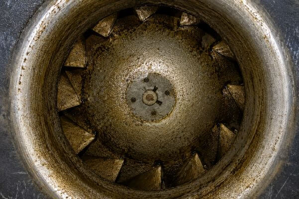 Commercial kitchen exhaust fan wheel coated with heavy grease buildup before exhaust system cleaning
